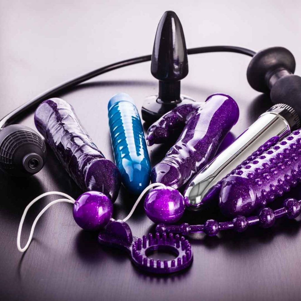 Sort anal plug med lilla dildo og vibrator samlet på mørk baggrund, silikone sexlegetøj til anal og vaginal stimulering