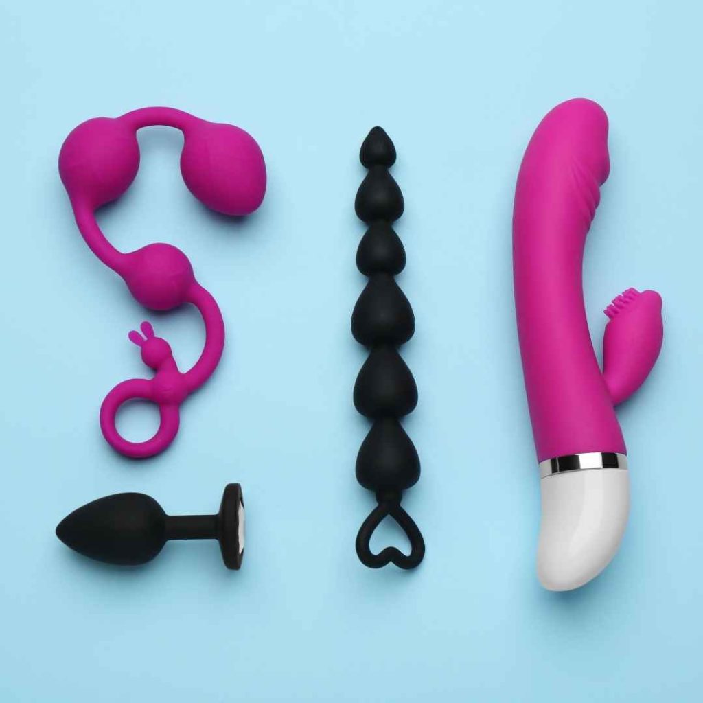 Sort anal plug, anal beads og pink vibrator på blå baggrund, sexlegetøj til anal og vaginal stimulering